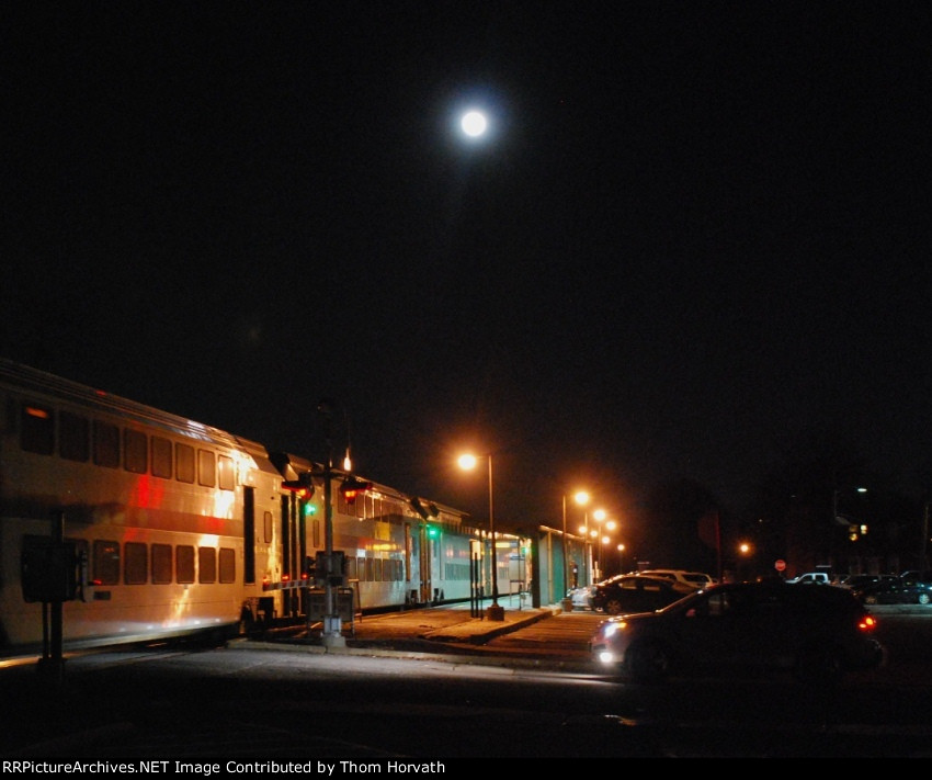 Its a full moon as a eastbound train rolls to a scheduled stop